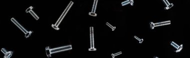panoramic shot of scattered metal bolts pattern isolated on black clipart