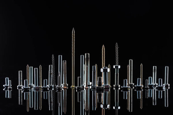 various shiny metallic screws isolated on black with copy space