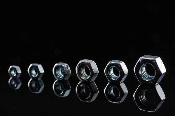 metal nuts of different sizes isolated on black