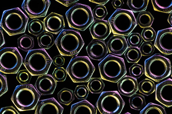 top view of shiny diverse metal nuts isolated on black