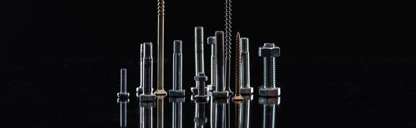 panoramic shot of various metallic screws isolated on black with copy space