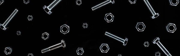 panoramic shot of scattered metal bolts and nuts pattern isolated on black