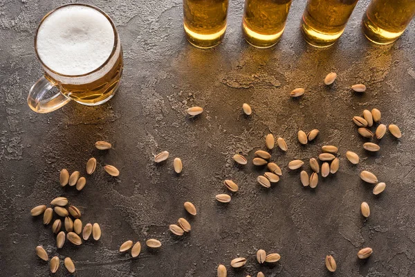 Top View Bottles Mug Light Beer Scattered Pistachios Brown Surface — Stock Photo, Image