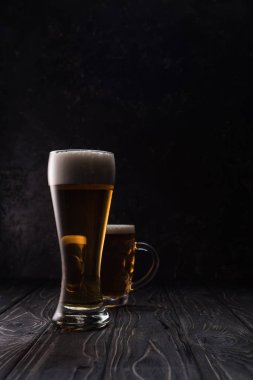 ahşap masa üzerinde köpük ile hafif bira cam ve kupa