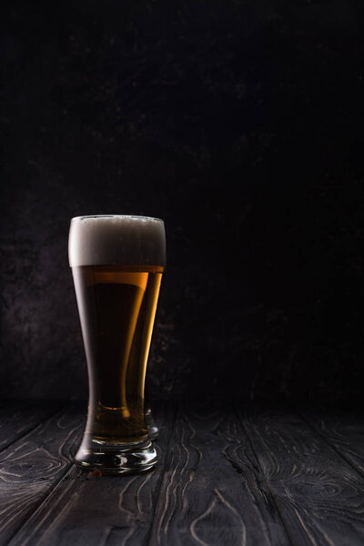 glass of fresh light beer on wooden table