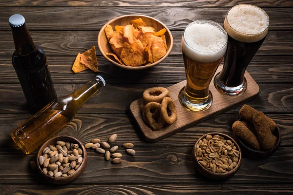 Garrafas Copos Cerveja Escura Leve Perto Tigelas Com Lanches Mesa — Fotografia de Stock