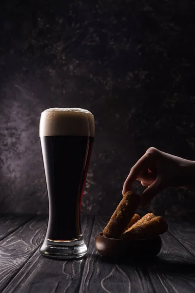 Cropped view of man taking piece of fried cheese near glass of beer on wooden table — Stock Image Cropped View Man Taking Piece Fried Cheese Glass Beer Wooden Royalty Free Stock Photos