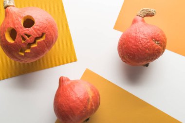 turuncu ve beyaz arka plan üzerine oyulmuş Halloween kabaküst görünümü