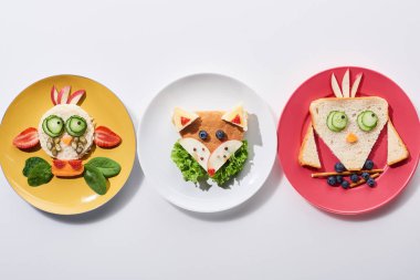 beyaz arka plan üzerinde çocuk kahvaltı için gıda yapılmış fantezi, kuş ve tilki ile plakalar üst görünümü