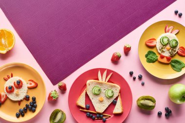 meyve ile pembe ve mor arka plan üzerinde gıda yapılmış fantezi hayvanlar ile tabak üst görünümü