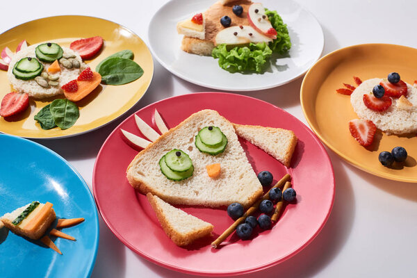 тарелки с модными животными, изготовленные из пищи для детей завтрак на белом фоне
