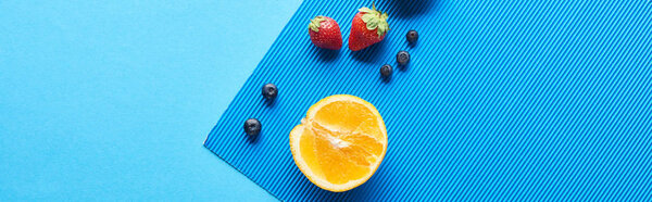 top view of fresh fruits on blue background, panoramic shot