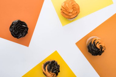 kopya alanı ile turuncu, sarı ve beyaz arka plan lezzetli Halloween cupcakes üst görünümü
