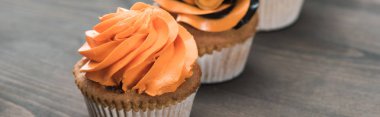 ahşap masa, panoramik çekim üzerinde lezzetli Halloween turuncu cupcake seçici odak