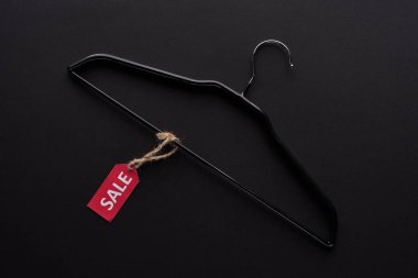 top view of hanger with sale label on black background clipart