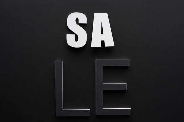 top view of sale lettering on black background