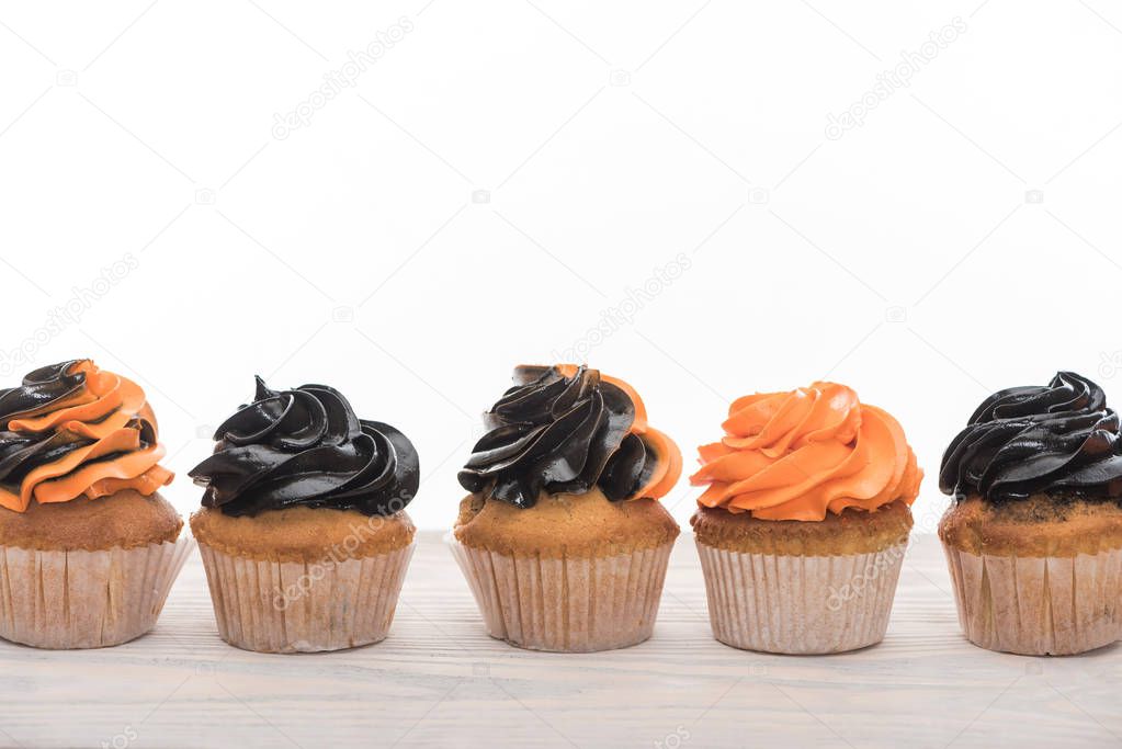 delicious Halloween orange and black cupcakes isolated on white with copy space