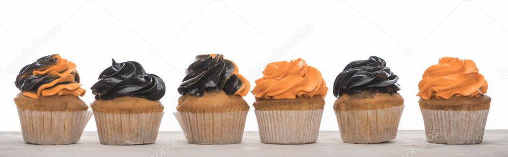 delicious Halloween orange and black cupcakes isolated on white, panoramic shot