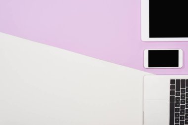 dizüstü bilgisayar, boş ekranlı dijital tablet ve mor ve beyaz arka planda akıllı telefon ile düz yatıyordu