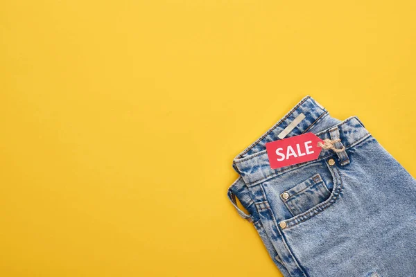 Vista Superior Jeans Com Etiqueta Venda Fundo Amarelo — Fotografia de Stock