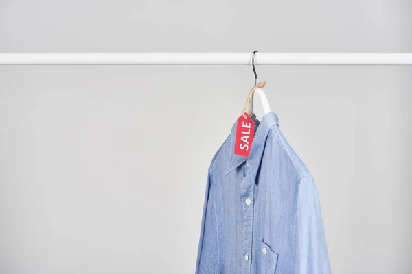 Camisa Azul Pendurada Com Etiqueta Venda Isolada Branco — Fotografia de Stock