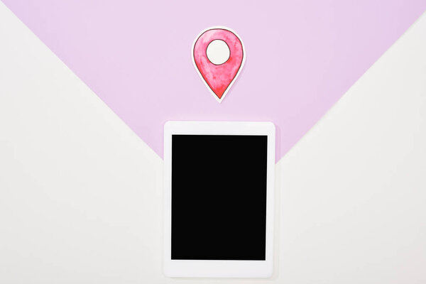 top view of digital tablet with blank screen and paper cut location mark icon on violet and white background