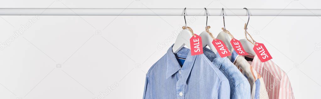 elegant shirts hanging with sale labels isolated on white, panoramic shot