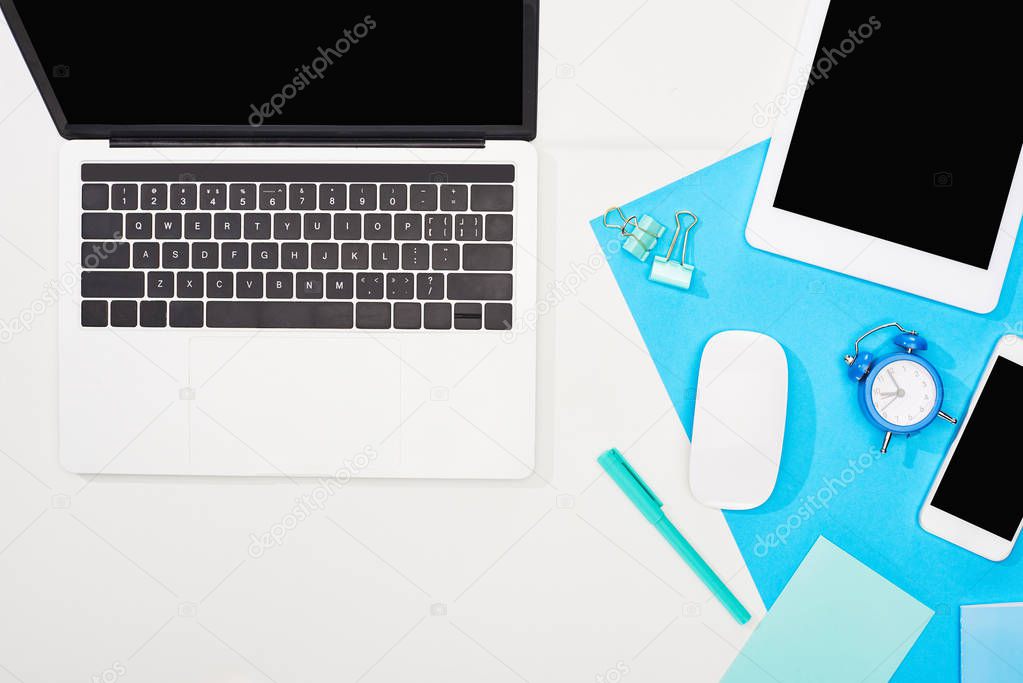 top view of gadgets with blank screen on blue and white background