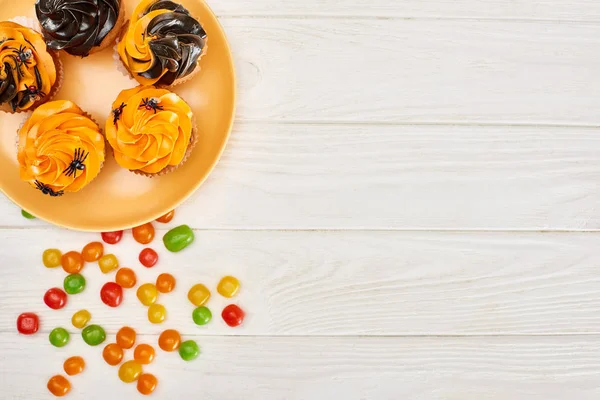 Draufsicht Auf Bunte Bonbons Der Nähe Orangefarbener Teller Mit Cupcakes — Stockfoto