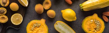 Tahta kesme tahtalarındaki sarı meyve ve sebzelerin üst görüntüsü gri desenli arka plan, panoramik çekim