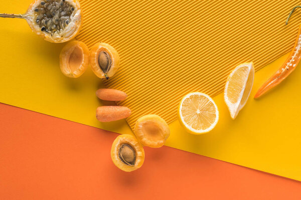 top view of fresh fruits and vegetables on yellow and orange background with copy space