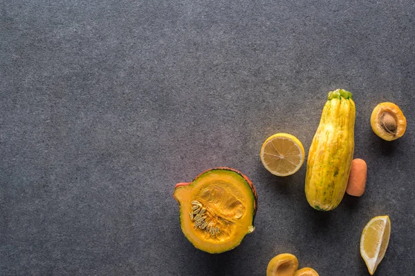 コピースペースのある灰色の質感の背景に黄色の果物や野菜のトップビュー — ストック写真