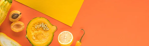 top view of yellow fruits and vegetables on orange background with copy space, panoramic shot