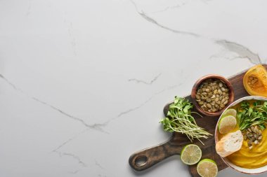 Sonbahar ezilmiş balkabağı çorbasının üst görüntüsü ahşap kesme tahtası mermer yüzey üzerinde kopya alanı ile