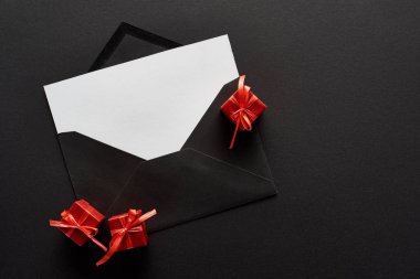 Siyah arkaplanda sunulan zarfın içindeki boş kartın üst görünümü