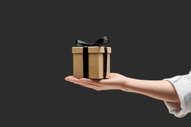 cropped view of woman holding gift box in hand isolated on black clipart
