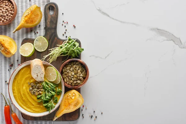 Top view of autumnal mashed pumpkin soup on wooden cutting board on marble surface — Stock Image Top View Autumnal Mashed Pumpkin Soup Wooden Cutting Board Marble Stock Photo