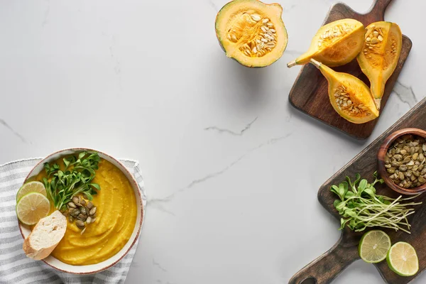 Top view of tasty mashed pumpkin soup on wooden cutting board with ingredients on marble surface — Stock Image Top View Tasty Mashed Pumpkin Soup Wooden Cutting Board Ingredients Stock Picture