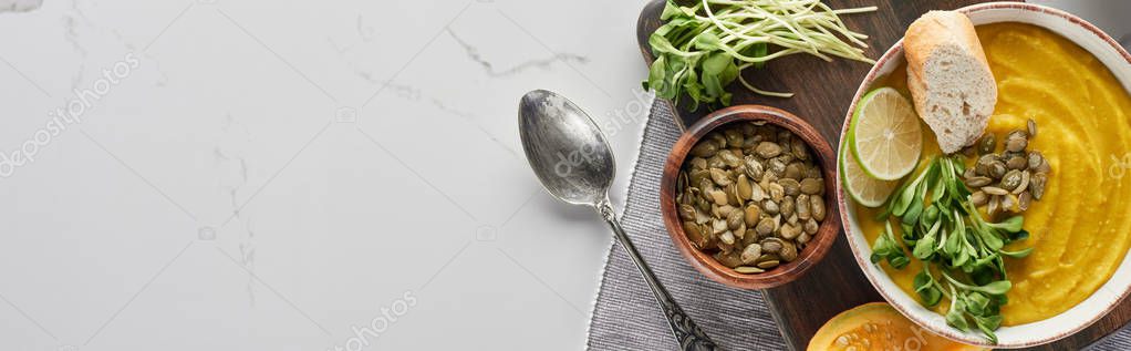 Panoramic shot of delicious mashed pumpkin soup on wooden cutting board on marble surface with ingredients — Stock Image Panoramic Shot Delicious Mashed Pumpkin Soup Wooden Cutting Board Marble Stock Image