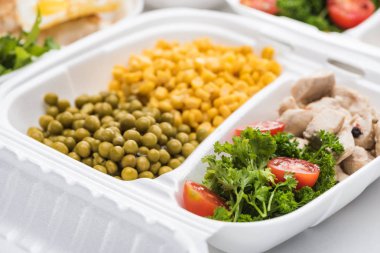 selective focus of eco package with vegetables, meat and salads on white background 