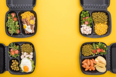 Elma, sebze, et, sahanda yumurta ve salata içeren ekolojik paketlerin üst görüntüsü sarı üzerine izole edilmiş. 