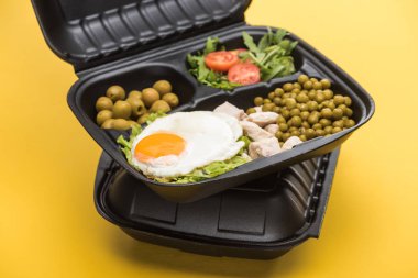 Çevre paketinde sebze, et, yumurta ve salata sarıya izole edilmiş. 