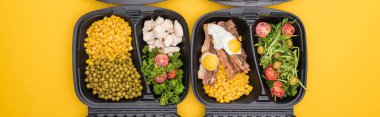 panoramic shot of eco packages with vegetables, meat, fried eggs and salads isolated on yellow     clipart