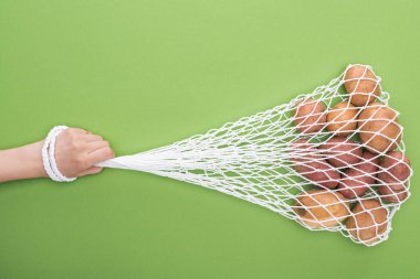 yeşil izole patates ile dize çanta tutan kadın kırpılmış görünümü