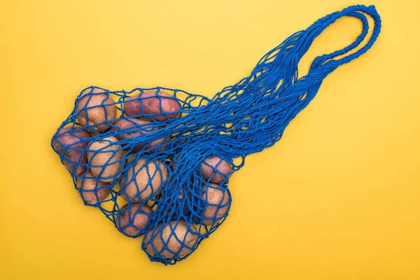 Top View Potatoes Blue String Bag Isolated Yellow — Stock Photo, Image
