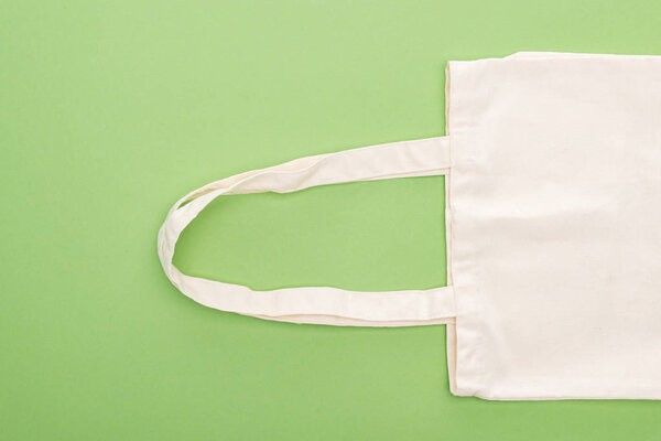 top view of empty cotton eco bag isolated on green