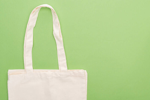 top view of empty cotton eco bag isolated on green