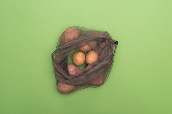 在绿色隔离的环保袋中新鲜全土豆的顶视图 — 图库照片
