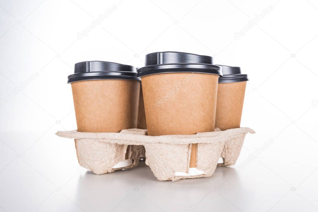 paper cups with coffee in cardboard tray on white background 