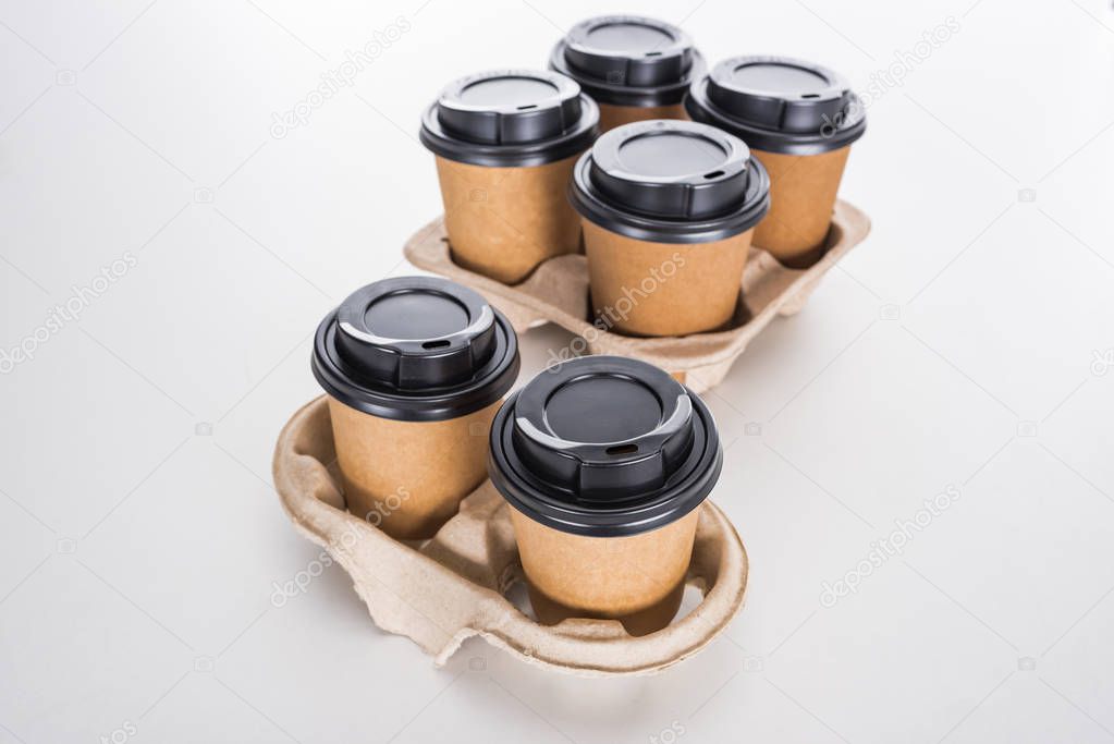 paper cups with coffee in cardboard tray on white background 